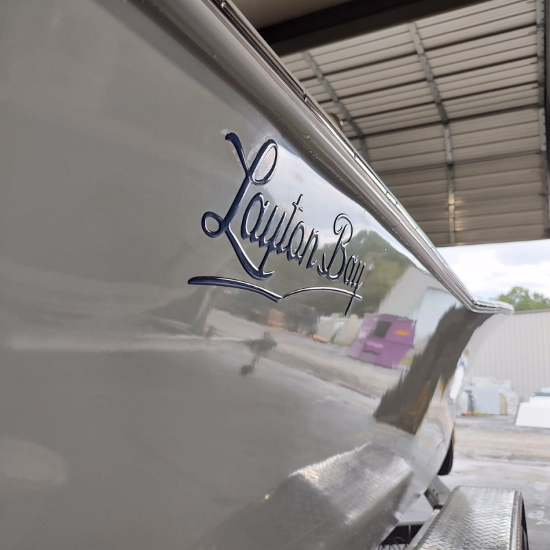 Shiny white boat hull with Layton Bay written in script on the side